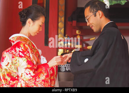 Hochzeit paar Austausch von Ringen in Shinto Trauung an Kusaga Taisha Shrine in Nara, Japan. Stockfoto