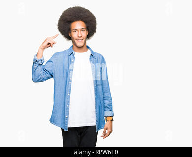 Junge afrikanische amerikanische Mann mit afro Haar Lächeln zeigte mit einem Finger zu Kopf, tolle Idee oder gedacht, gutes Gedächtnis Stockfoto