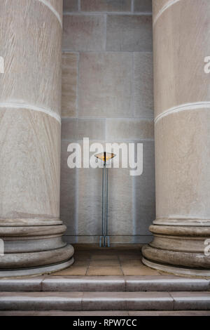 Griechische Wiederbelebungarchitektur künstlerische Standleuchte Wandleuchte oder Befestigung zwischen zwei massiven Beton oder Marmorsäulen in Montgomery Alabama, USA. Stockfoto