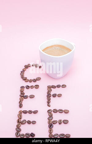 Text aus Kaffeebohnen: Kaffee. Textur der Kaffeebohnen auf einem rosa Hintergrund. Stinkende, satten Braun arabischen Kaffee Bohnen. Kopieren Sie Platz. Stockfoto