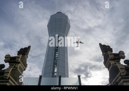 Denpasar, Bali - Januar 12 2018: Leuchtturm am Hafen von Benoa. Wenn der Wind aus dem Westen weht, Flugzeuge, die auf dem Flughafen Ngurah Rai landen Stockfoto