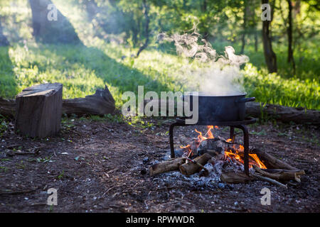 Kochen über einem Lagerfeuer in einem Waldgebiet in Kent, Großbritannien Stockfoto