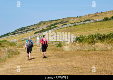 Menschen zu Fuß an der Küste entlang durch Durlston Country Park und Naturreservat, Swanage, Dorset, Großbritannien. Insel Purbeck Stockfoto