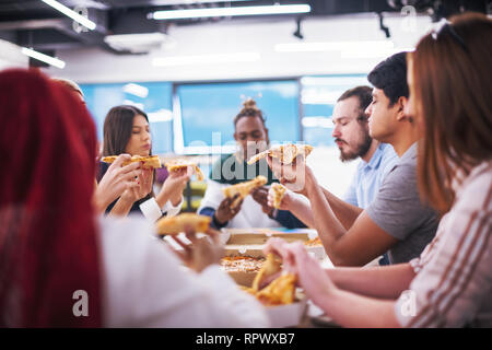 Freundlich diverse multiethnischen Business Team Essen teilen Pizza zusammen im Startup office, multirassischen Mitarbeiter Mitarbeiter Gruppe genießen Pause sprechen. l Stockfoto