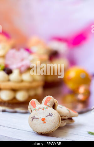 Orange Makronen mit Schokoladenfüllung und Osterhase Makronen, auf Orange tüll Hintergrund Stockfoto