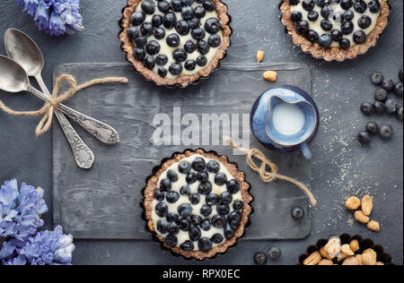 Draufsicht auf Vollkorn blueberry Torten mit Vanillecreme auf dunklem Hintergrund Stockfoto