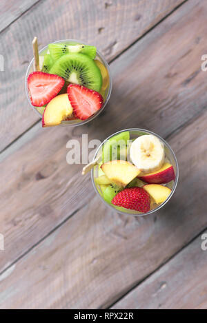Obstsalat in Plastik Becher zum Mitnehmen. In Scheiben geschnitten Bio Früchte und Beeren, gesunden Snack zu gehen, Platz kopieren. Stockfoto