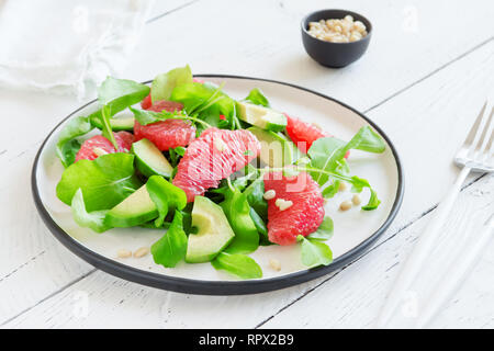 Avocado und Grapefruit Salat Salat mit Rucola und Pinienkernen, hautnah. Raw vegan vegetarisch Frühling Zitrusfrüchte detox Salat, gesundes Essen. Stockfoto