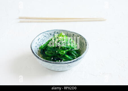 Chuka Algensalat in Keramik Schüssel über weißen Hintergrund, kopieren. Japanische Küche - Chuka Salat Stockfoto