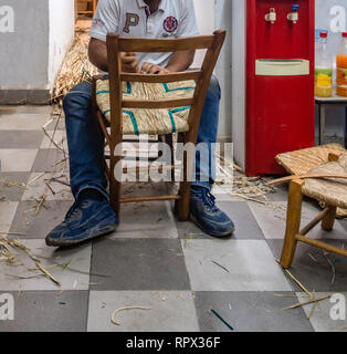 Limassol, Zypern n - 9 November 2018: Detailansicht des Handwerkers, eine typische zypriotische Holzstuhl. Zeigt ihm das Weben der Sitz. Mit lokalen Schilf. Stockfoto
