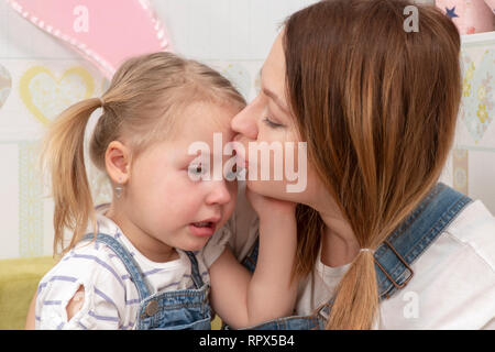 Die Mutter küsst sie weint Tochter auf der Stirn, beruhigenden Ihr Stockfoto