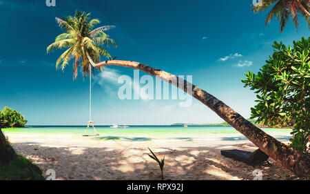 Natur Landschaft tropischer Strand mit Landschaft Kokospalme, kristallklares Meer Wasser auf Hintergrund blauer Himmel Stockfoto