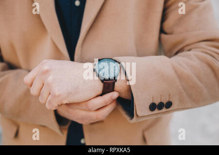 Nahaufnahme Detail der Accessoire für Männer - ein Mann der Zeit überprüfen und korrigieren Sie den Riemen auf seine Armbanduhr. Stockfoto