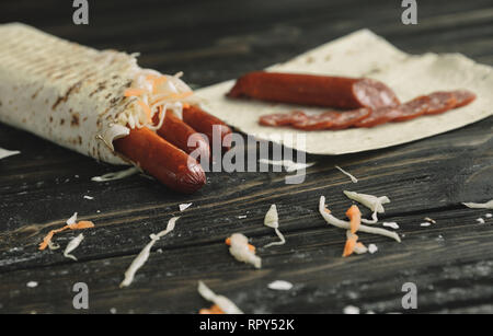 Geräucherte Wurst in pita Brot auf einem Holztisch Stockfoto