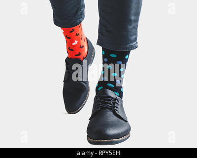 Geschäftsmann, trendige Schuhe, blaue Hosen und Helle, bunte Socken mit einem Muster von Polka Dots auf einem weißen Hintergrund, isoliert. Close-up. Für Stockfoto