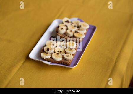 Bananen Toast mit Erdnussbutter, Kakaokerne und Honig Stockfoto