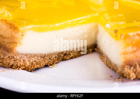 Zitronen- Käsekuchen, verziert mit einer Zitronenschale hautnah. Selektiver Fokus Stockfoto