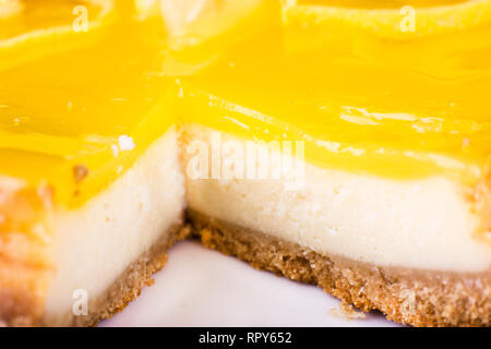 Zitronen- Käsekuchen, verziert mit einer Zitronenschale hautnah. Selektiver Fokus Stockfoto