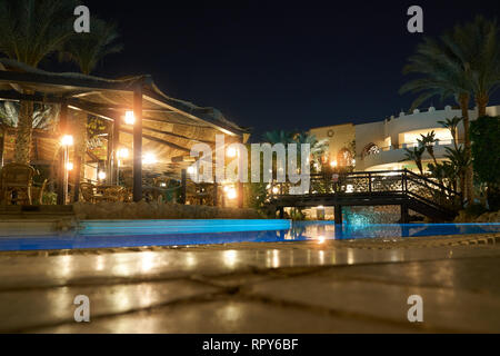 Sharm El Sheikh, Ägypten - Februar 9, 2019: Nacht 5-Sterne Grand Hotel mit Palmen und Swimmingpool auf der Terrasse entlang der Küste Stockfoto