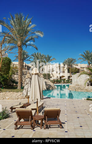 Sharm El Sheikh, Ägypten - Februar 9, 2019: 5-Sterne Grand Hotel mit Palmen und Liegestühlen in der Nähe von Schwimmbad im Sommer Stockfoto
