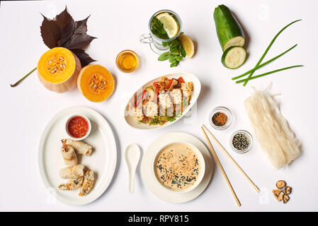 Flach von orientalischem Abendessen von der Suppe mit Samen, Tempura Garnelen und Nudeln mit Gemüse vorbereiten für Client. Drei Gerichte zum Mittagessen mit Pfefferminztee r Stockfoto