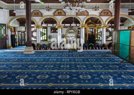 Männer beobachten Mittag Gebete, die Kampung Kling Moschee Masjid Kampung Kling, Melaka, Malaysia. Stockfoto