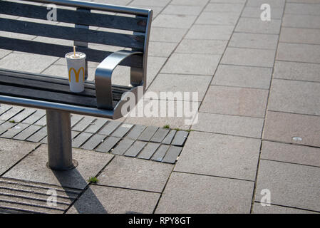 Stratford-upon-Avon, Warwickshire, England UK 22. Februar 2019 Kunststoff Mcdonalds Cup auf der Parkbank mit Platz für Überschrift Stockfoto