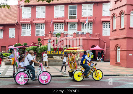 Melaka, Malaysia. Trishaws Pass ich Liebe Melaka Zeichen vor Stadthuys, Niederländisch: Governor's Residence und Rathaus, erbaut 1650. Stockfoto