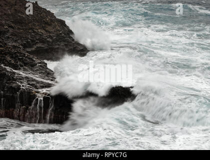 Eine Welle bricht bei stürmischem Wetter auf einem Riff vor einer felsigen Küste, Wasser Bewegung in lange Belichtung - Ort: Spanien, Kanarische Inseln, La Palma Stockfoto