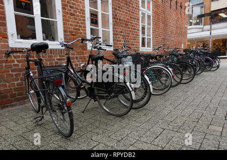 Linie der Fahrräder auf Bürgersteig geparkt. Oldenburg. Niedersachsen. Deutschland. Stockfoto