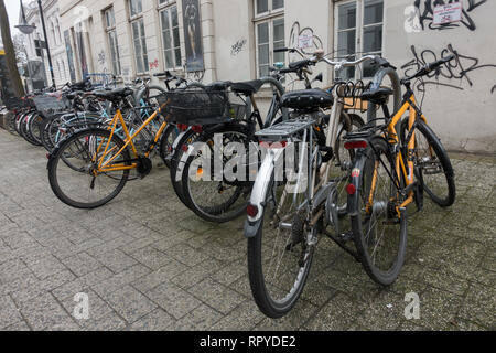 Große Gruppe von Fahrrädern auf Kopfsteinpflaster geparkt. Oldenburg. Niedersachsen. Deutschland. Stockfoto