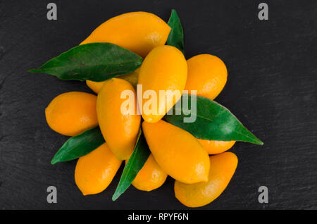 Helles orange Kumquats auf schwarzem Hintergrund. Studio Foto Stockfoto