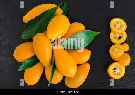 Helles orange Kumquats auf schwarzem Hintergrund. Studio Foto Stockfoto