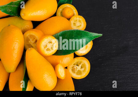 Helles orange Kumquats auf schwarzem Hintergrund. Studio Foto Stockfoto