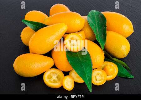 Helles orange Kumquats auf schwarzem Hintergrund. Studio Foto Stockfoto