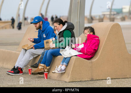 Blackpool, Lancashire. 23. Februar, 2019. UK Wetter. Hell, sonnig warmen Tag an der Küste. Urlauber, Touristen und Besucher das Resort einen kurzen Zauber, der am Ufer des Meeres genießen als Menschen genießen Sie Fisch & Chips. Credit: MWI/AlamyLiveNews Stockfoto