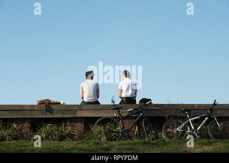 Hampstead Heath, London, UK. 23. Februar, 2019. Das Met Office wird die Vorhersage Temperaturen in Großbritannien zeichnet diese Wochenende brechen könnte, mit hohem Druck aus Europa bringt trockenes und sonniges Wetter. Im Bild, 2 junge Männer in der Sonne entspannen. © Credit: Byron Byron Kirk Kirk/Alamy leben Nachrichten Stockfoto