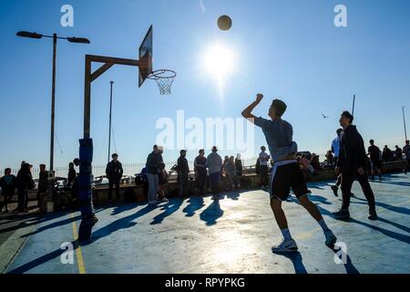 Brighton, Sussex, UK. 23. Februar, 2019. Menschen spielen Basketball am Strand Gerichte in Brighton im hellen Frühling - wie Winter Sonne am Samstag, Februar 23, 2019. Credit: Julie Edwards/Alamy leben Nachrichten Stockfoto