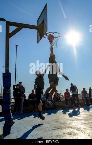 Brighton, Sussex, UK. 23. Februar, 2019. Menschen spielen Basketball am Strand Gerichte in Brighton im hellen Frühling - wie Winter Sonne am Samstag, Februar 23, 2019. Credit: Julie Edwards/Alamy leben Nachrichten Stockfoto