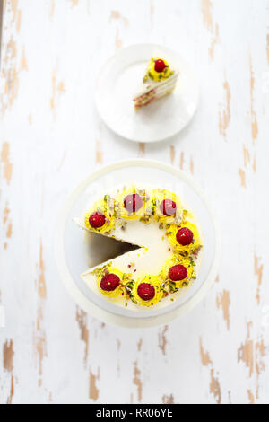 Schöne happy birthday cake mit Mascarpone mit Himbeere, Pistazie und Kerzen auf der Torte stand eingerichtet. Ansicht von oben Stockfoto