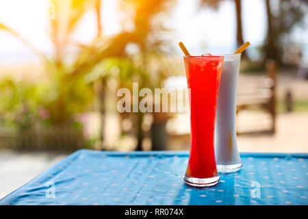 Tequila Sunrise und Pina Colada Cocktails auf dem Tisch unter den Palmen im Freien Stockfoto