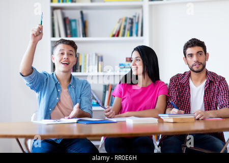 Kaukasische männliche Kursteilnehmer Hand in Klassenzimmer der Schule Stockfoto