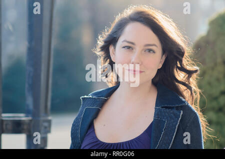 Hübsche Frau mit langen dunklen Haaren draußen Stockfoto