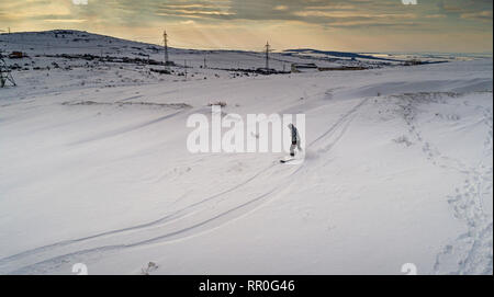 Snowboarden Overhead Top Down Sicht der Snowboarder Reiten durch frischen Pulverschnee, Ski Resort oder Backcountry Hang Stockfoto