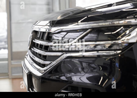 Seitenansicht des neuen, teuren, schwarzen Automobils hautnah. Stilvolle, Scheinwerfer und Stoßfänger des Fahrzeugs. Konzept der Kauf Fahrzeug Auto Dealership Showroom. Stockfoto