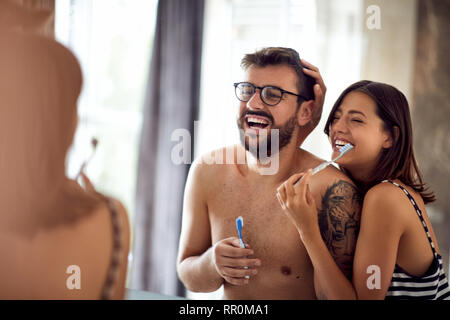Glückliches Paar ihre Zähne putzen am Morgen zu Hause im Badezimmer zusammen Stockfoto
