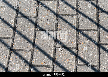 Diagonale Schatten der Geländer auf dem Bürgersteig an einem sonnigen Februartag in London, Vereinigtes Königreich Stockfoto