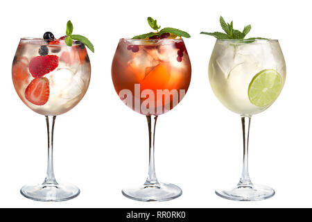 Alkoholische und nicht-alkoholische Cocktails mit Minze, Früchte und Beeren auf einem weißen Hintergrund. Drei Cocktails im Glas Gläser auf einem langen Bein. Isoliert. Stockfoto