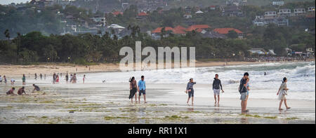 Chinesische Touristen im Urlaub Urlaub am Strand bei Sonnenuntergang in der Bucht von Jimbaran Bali Indonesien Stockfoto