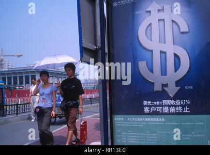 Chinesische Fußgänger vorbei an einer Anschlagtafel der Dollar Investitionen in Peking, China. 2005 Stockfoto